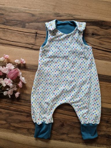 Bunte Babykleidung mit gepunktetem Design und blauer Türausschnitt.